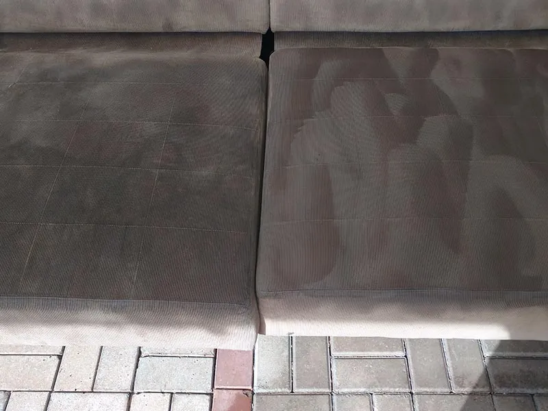 Sofá de tecido durante a higienização, com a diferença visível entre o lado limpo e o lado sujo